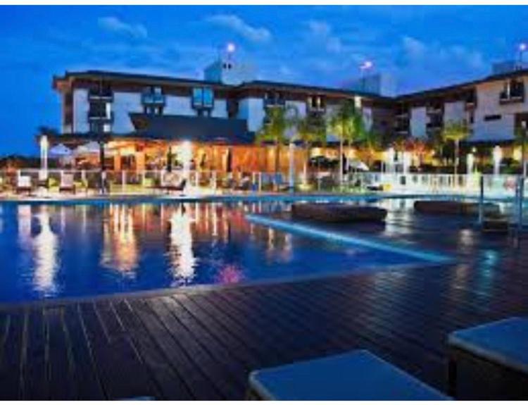 a large swimming pool in front of a building at night at Flat na Beira do Lago 5min da Esplanada dos Ministérios in Brasília