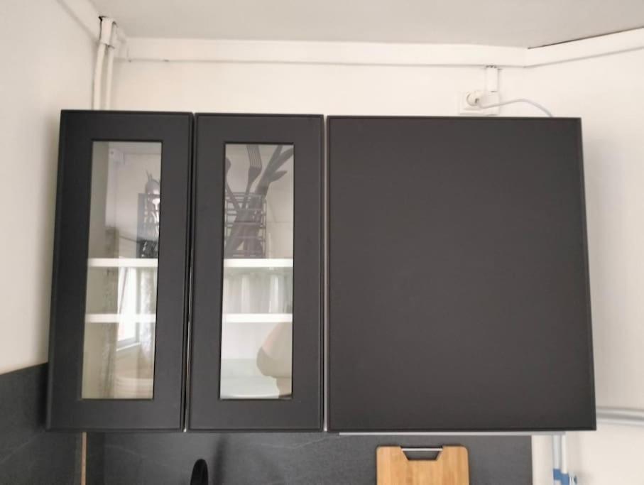 a black cabinet with three windows in a room at Petit cocon sur Coudekerque-Branche in Coudekerque-Branche