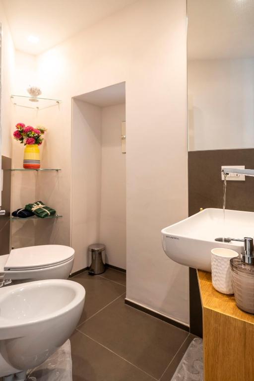 a bathroom with a toilet and a sink and a tub at Martini Matera 2-luxury apartment in Matera