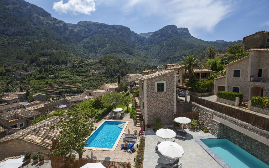 een villa met een zwembad en bergen op de achtergrond bij Hotel y Apartamentos DES PUIG in Deia