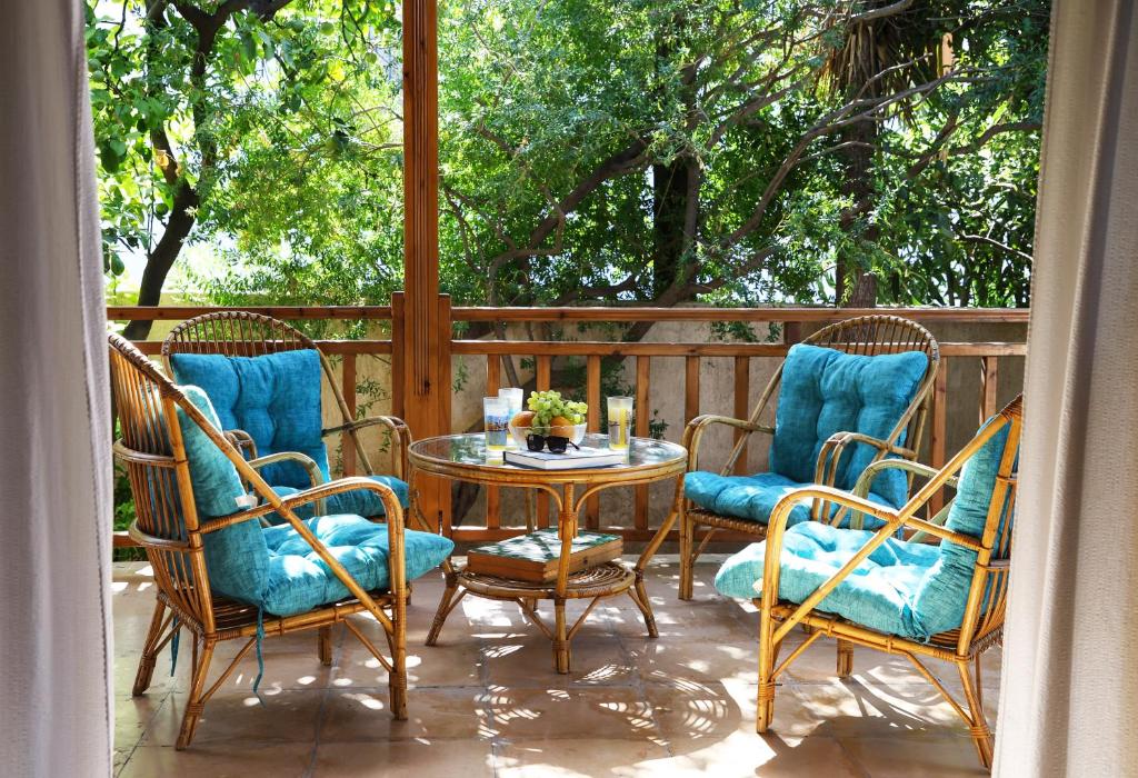 a patio with a table and four chairs and a table at Belle Epoque - Holiday Home in Aegina Town