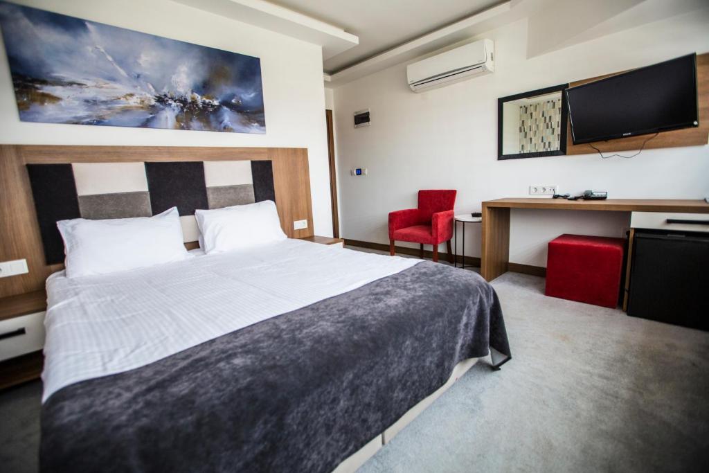a bedroom with a bed and a desk and a tv at RİVADA HOTEL in Kartepe