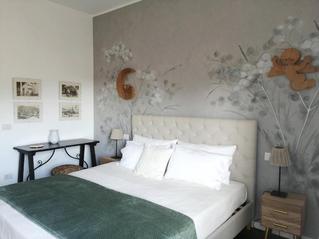 1 dormitorio con cama blanca y pared de flores en Casa di Enri, en Como