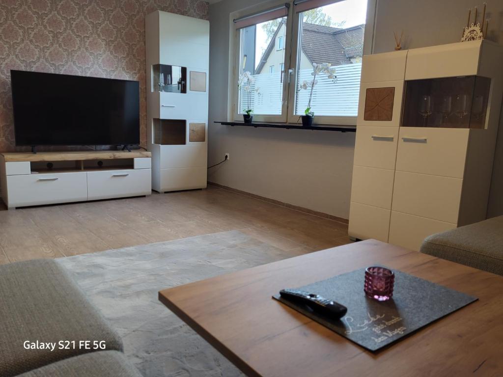 ein Wohnzimmer mit einem TV und einem Couchtisch in der Unterkunft Apartment Bochum in Bochum