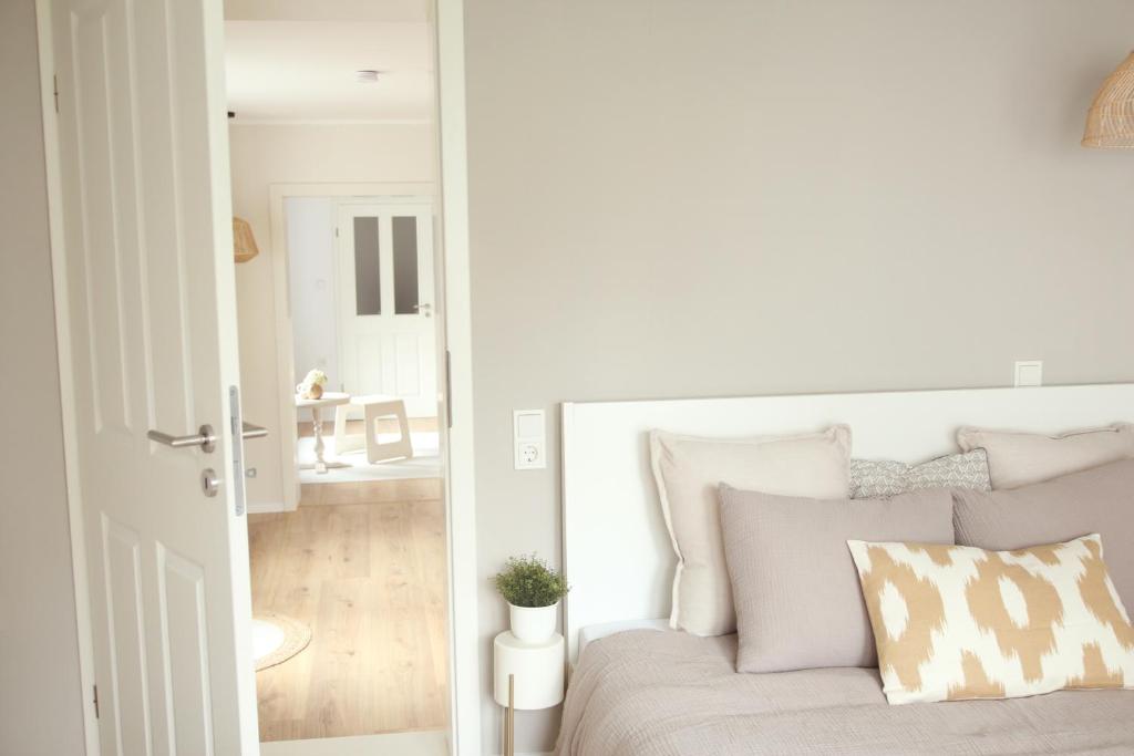 a white bedroom with a bed with pillows at Im Fachwerk – Wohlfühlen, Entspannen & Wandern im Grünen in Gladenbach