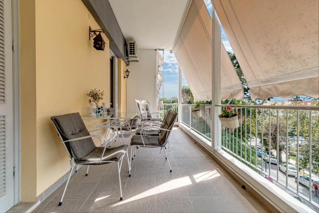ein Esszimmer mit einem Tisch und Stühlen auf dem Balkon in der Unterkunft Bella Venezia Residence in Korfu-Stadt