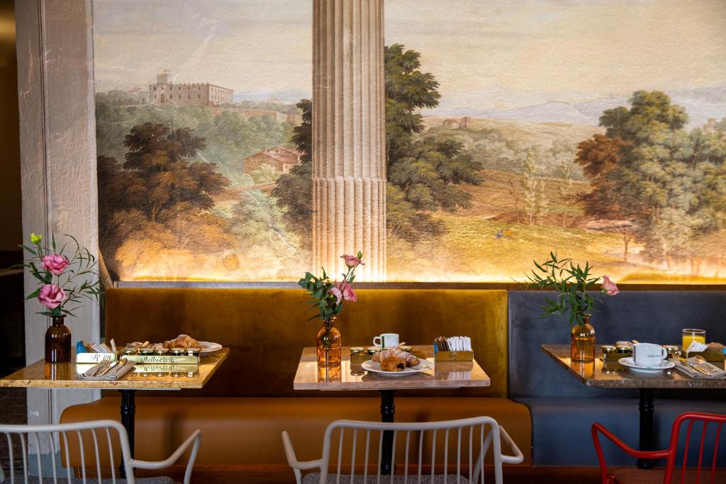 two tables in a restaurant with a painting on the wall at Stella d'Italia in Florence