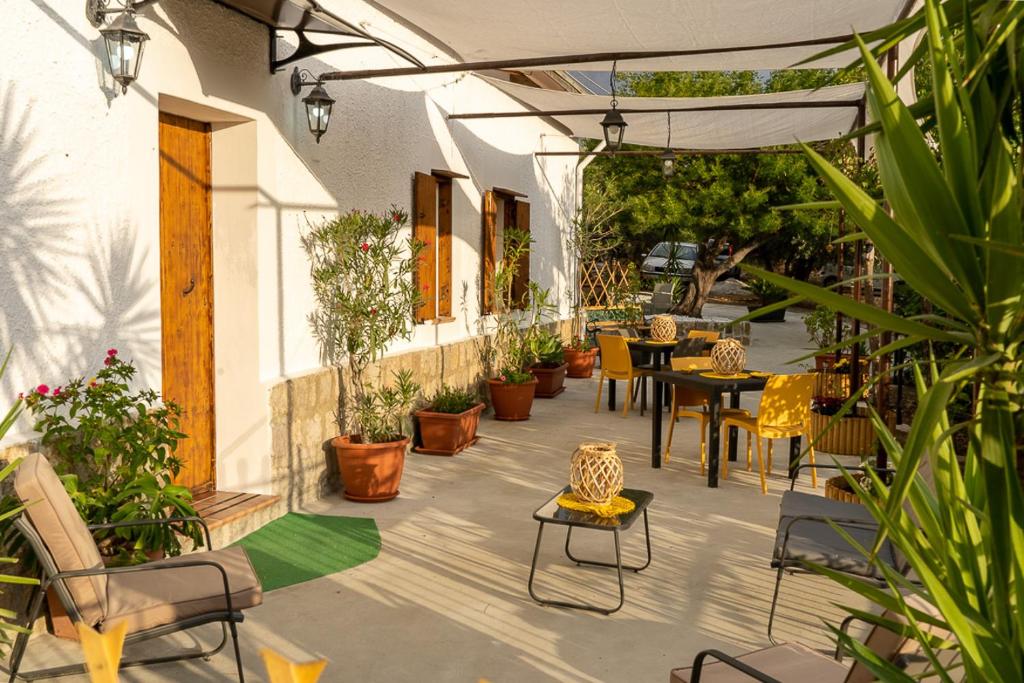 een patio met tafels, stoelen en planten bij Casa Vacanze Lachesi in Caccamo
