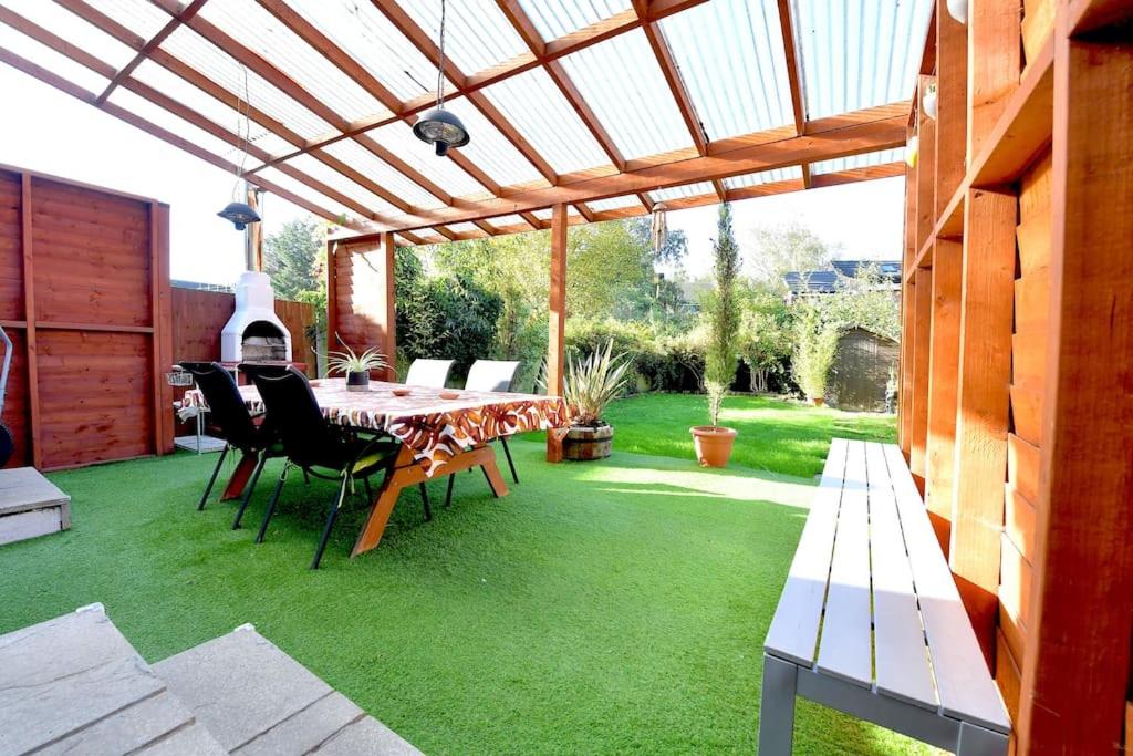 a patio with a table and chairs under a pergola at Colindale Retreat, Sleeps 6 people in Colindale