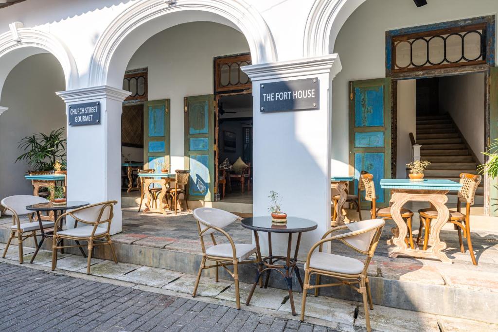 un groupe de tables et de chaises à l'extérieur d'un bâtiment dans l'établissement The Fort House, à Galle