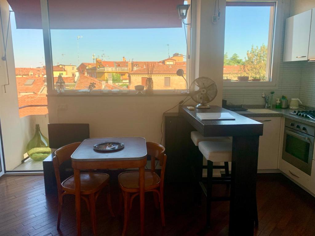een keuken met een tafel en stoelen en een raam bij Charming Home Towers-Roofs View in Bologna