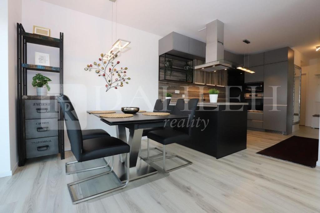 a kitchen and dining room with a table and chairs at Einpark Fabulous Apartment with Private parking in Bratislava