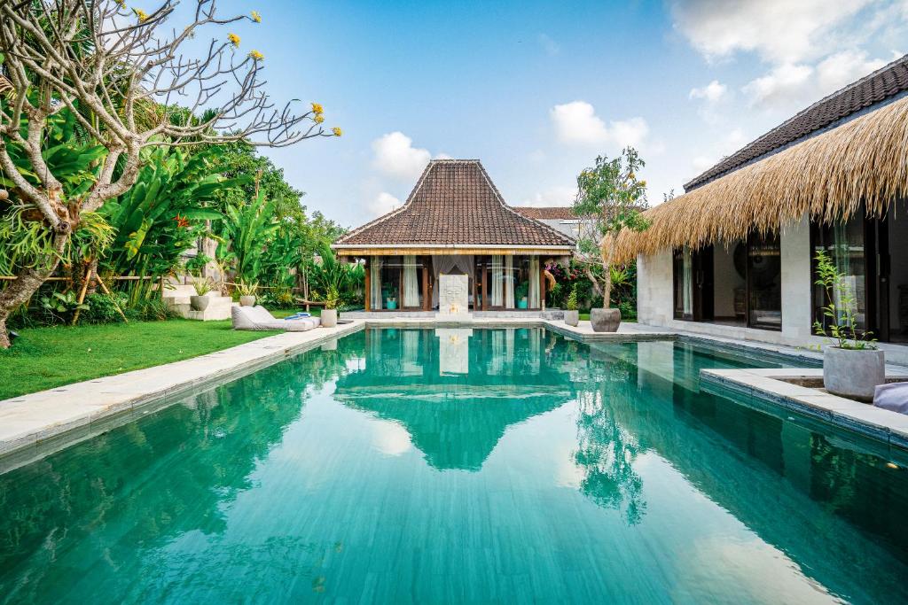 a swimming pool in front of a house at Villa Almar in Dalung