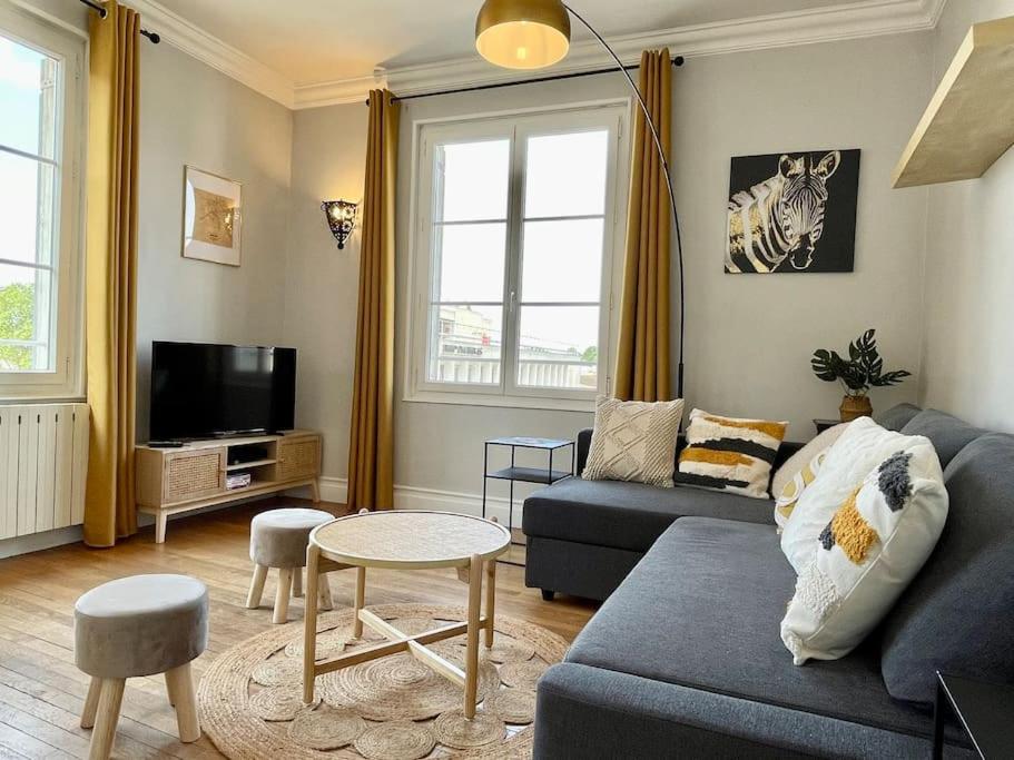 a living room with a blue couch and a tv at Suites Rive Gauche - Région Fontainebleau - Chez Victor in Melun