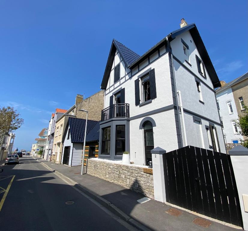 - un bâtiment blanc et noir dans une rue de la ville dans l'établissement Villa Clin d'œil - Villa De knipoog, à Wimereux