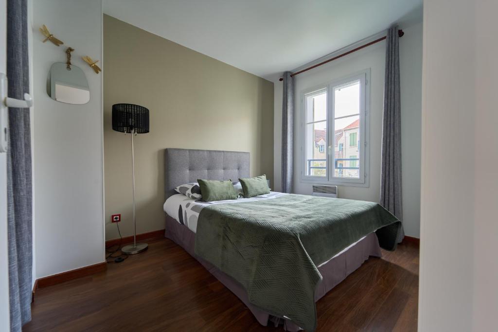 a bedroom with a bed and a window at Charmant Duplex 2 chambres pour 6 personnes - 10 min Disneyland - Free Parking in Bailly-Romainvilliers