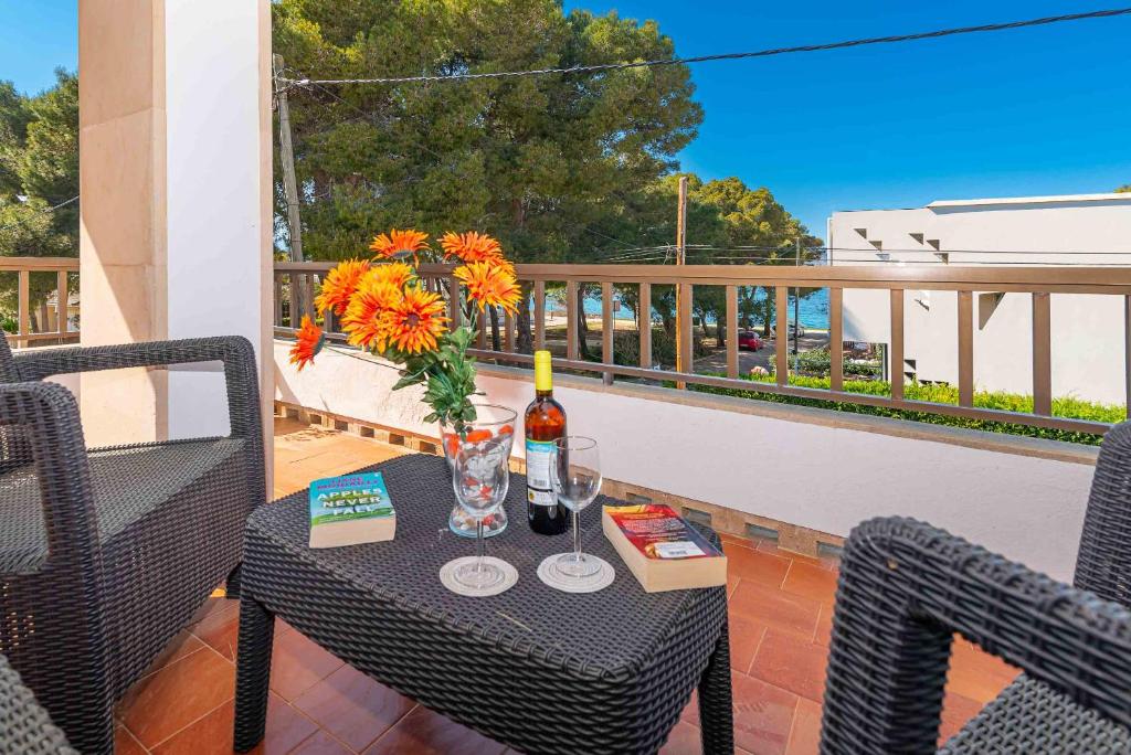 einen Tisch mit einer Flasche Wein und Blumen auf dem Balkon in der Unterkunft Villa Francesca in Port d'Alcúdia