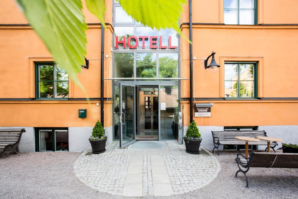 a hotel entrance with benches in front of a building at Akademihotellet in Uppsala