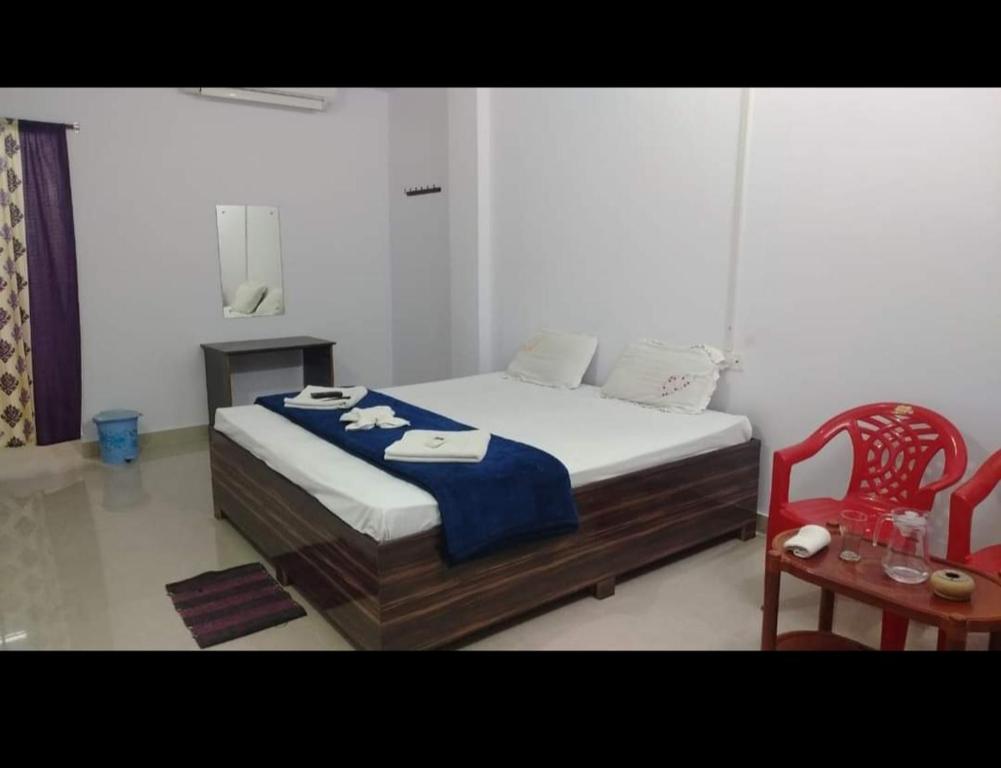 a bedroom with a bed and a red chair at port Blair in Port Blair