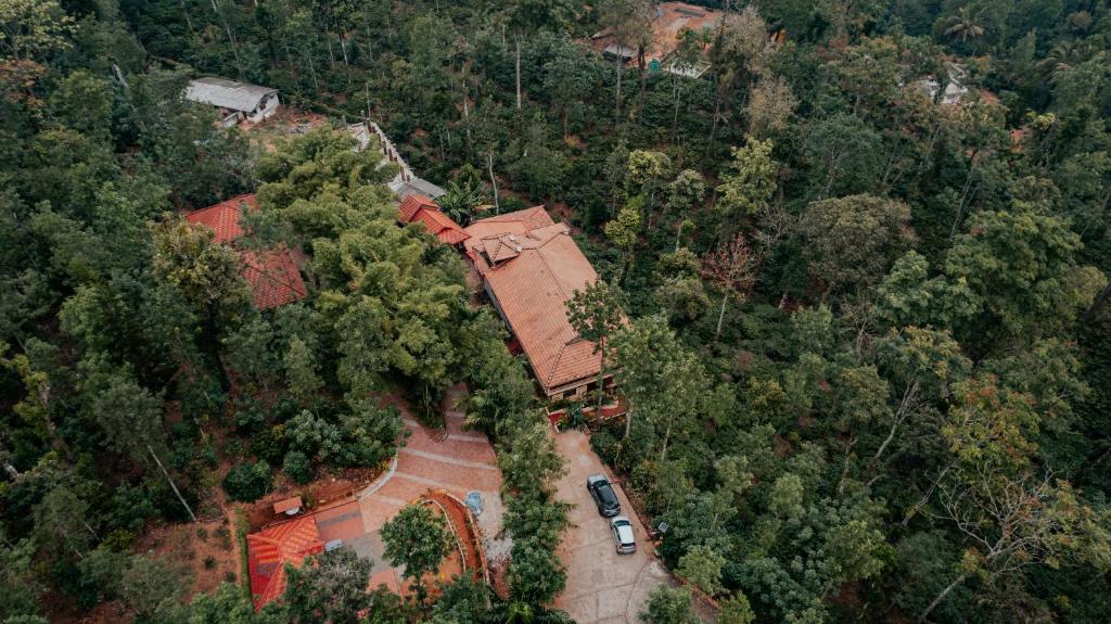 uma vista aérea de uma casa no meio de uma floresta em KINGMAKER'S Plantation with River Stream em Madikeri