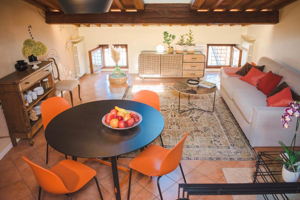 uma sala de estar com uma mesa com uma taça de fruta em Vicolo Amanti Verona em Verona