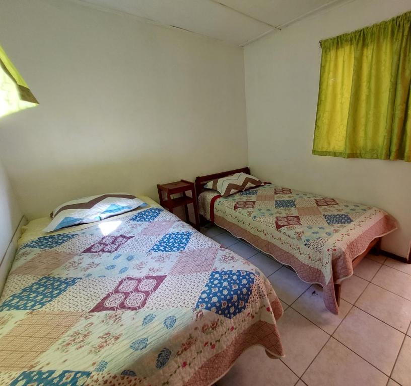 two beds in a room with a quilt at Hostal Venecia in Arica