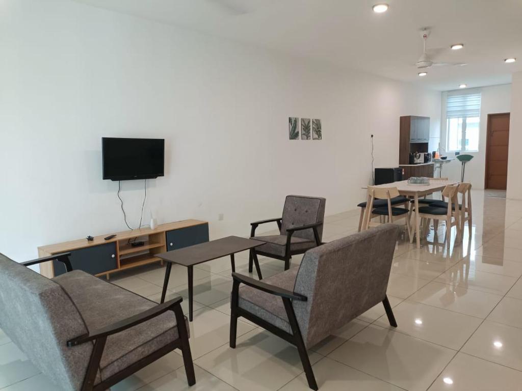 een woonkamer met stoelen en een flatscreen-tv bij Cozy 4 bedrooms House by Mr Homestay, 3 mins to Kulim Landmark Centre in Kulim