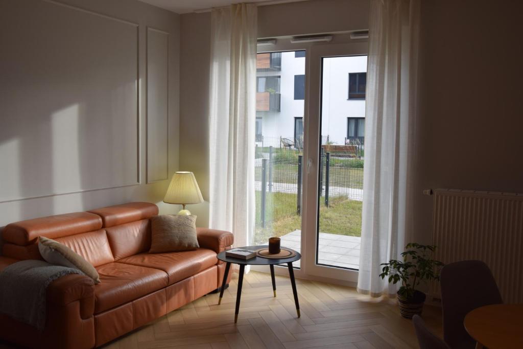 a living room with a couch and a table and a window at Warsaw City Break II in Pruszków