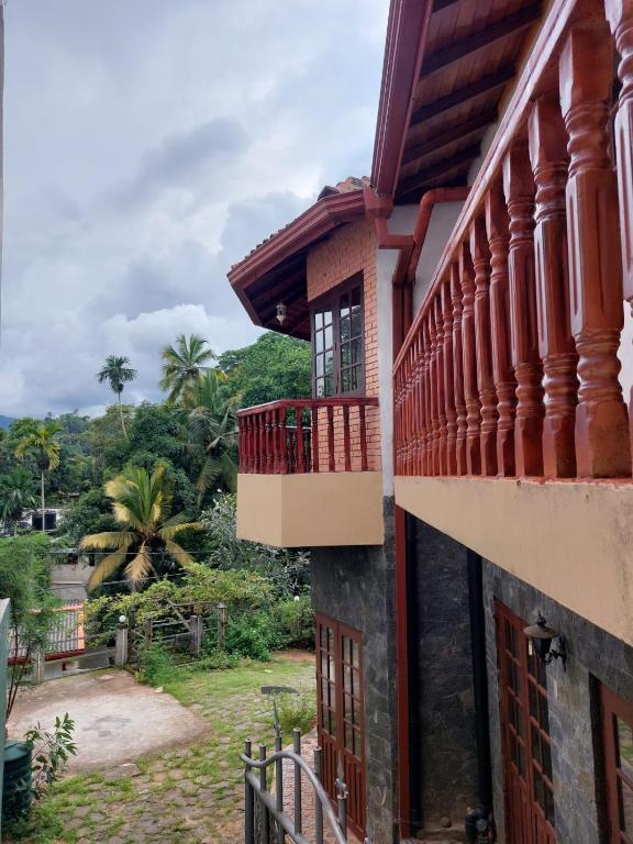 a building with red balconies and a yard at Mystique Hideout in Kandy