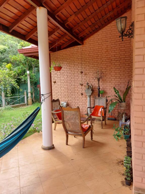 a patio with chairs and a hammock in a house at Mystique Hideout in Kandy
