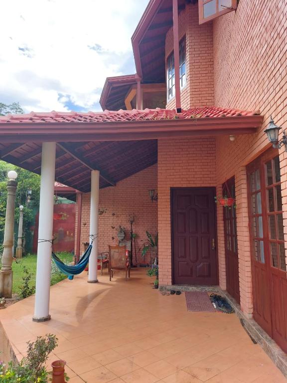 a patio with awning and a hammock under a house at Mystique Hideout in Kandy