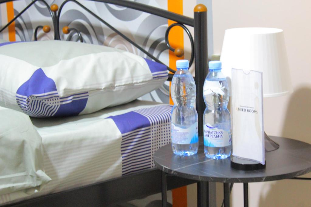 duas garrafas numa mesa ao lado de uma cama em Uneed Rooms Petropavlivska em Kiev