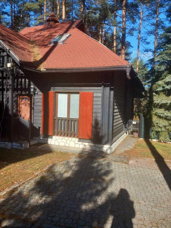 a small house with a red roof and a driveway at APARTMAN ZELENA DOLINA in Čajetina