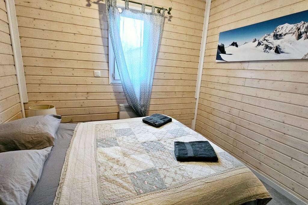 Le Chalet Du Redon في مارجونْسيل: غرفة نوم بسرير مع نافذة وبطانية