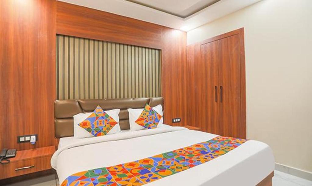 - une chambre avec un grand lit et un mur en bois dans l'établissement FabHotel The Treenity House, à Allahābād