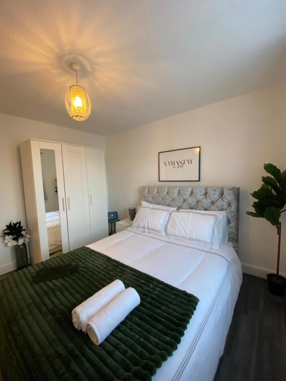 um quarto com uma cama grande com duas toalhas em Cosy Apartment Near Bluewater With Private Parking em Kent