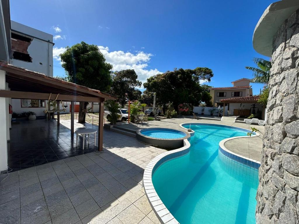 a swimming pool in a yard next to a building at Pousada Itaúnas in Conceição da Barra