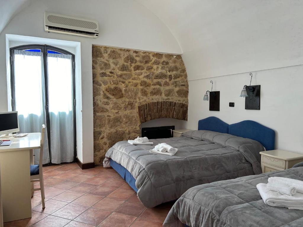 a bedroom with two beds and a desk with a computer at B&B Centro Storico in Caltanissetta