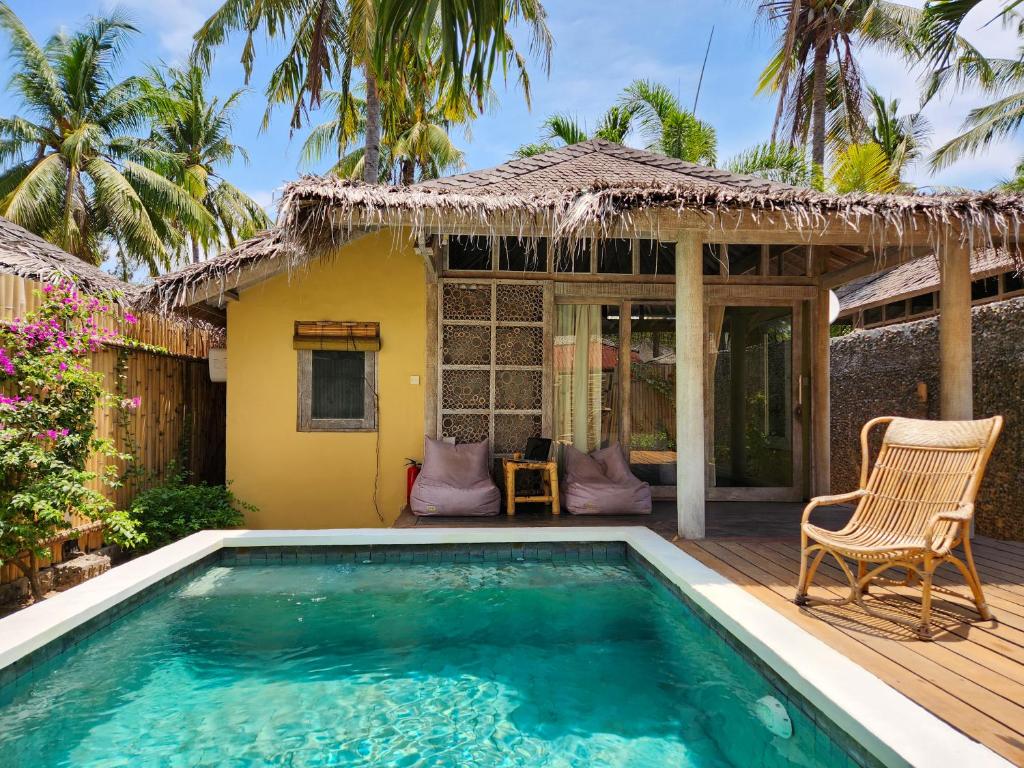 a villa with a swimming pool and a deck at Villa Bamboo in Gili Trawangan