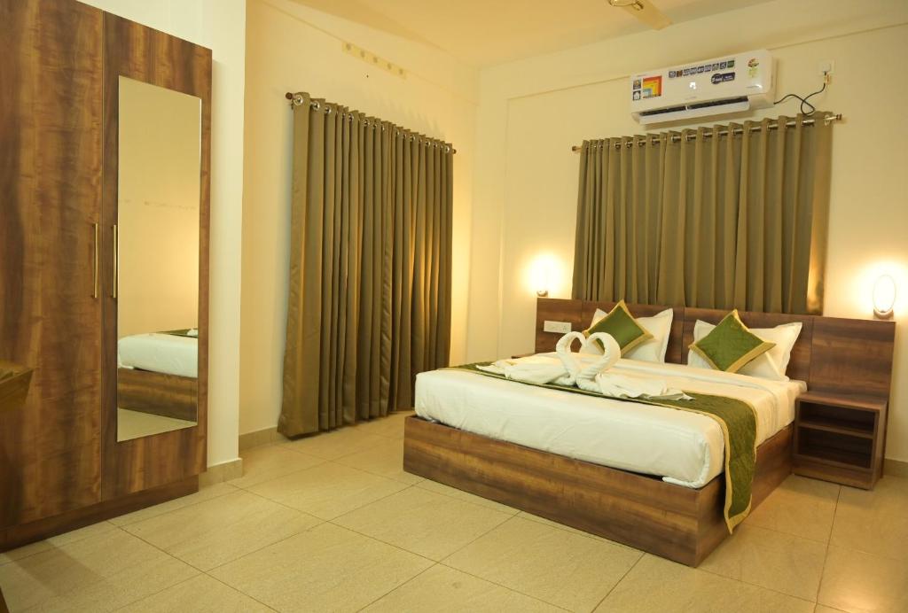 a bedroom with a bed and a large mirror at JAY KAY RESIDENCY in Ernakulam