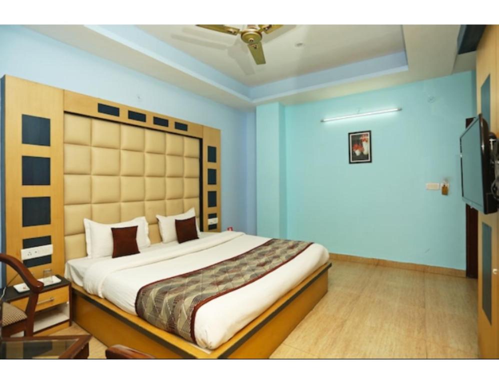a bedroom with a large bed in a blue room at Hotel Kolam, Dehradun in Dehradun