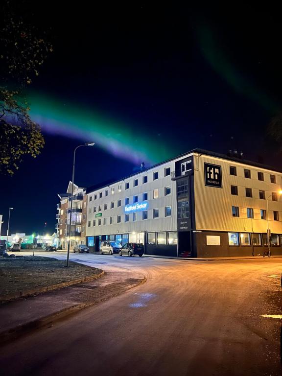 un bâtiment avec un feu vert au-dessus de celui-ci la nuit dans l'établissement Fast Hotel Svolvær, à Svolvær