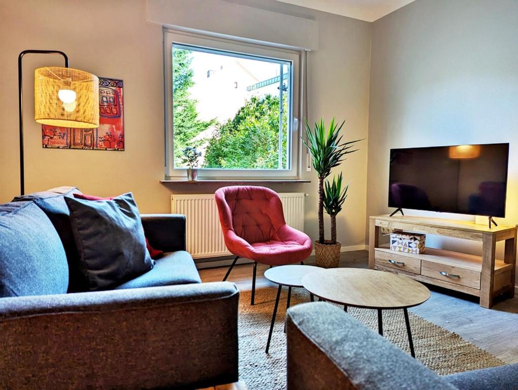 ein Wohnzimmer mit einem Sofa und einem TV in der Unterkunft Apartmenthaus GOLDGRUBE in Koblenz