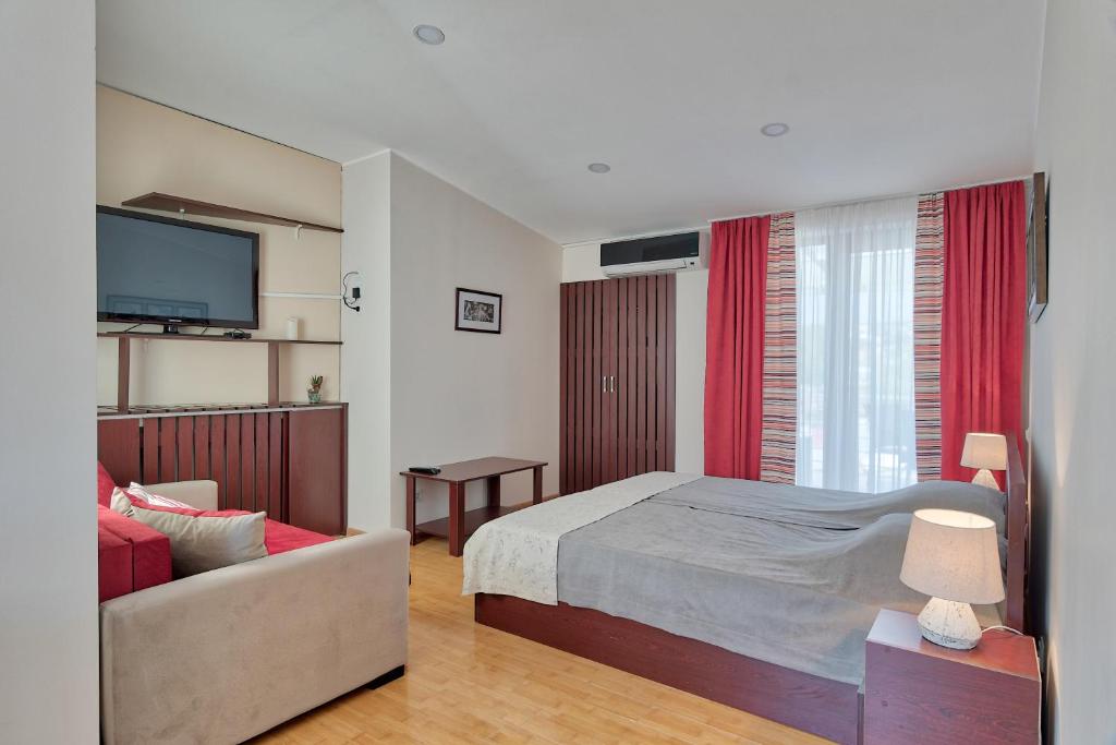 1 dormitorio con cama, sofá y TV en New Tiflis Apartment Plekhanovi, en Tiflis