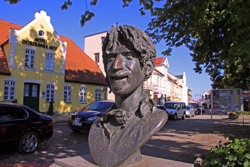 a statue of a bust of a man on a street at Hotel Doberaner Hof in Bad Doberan