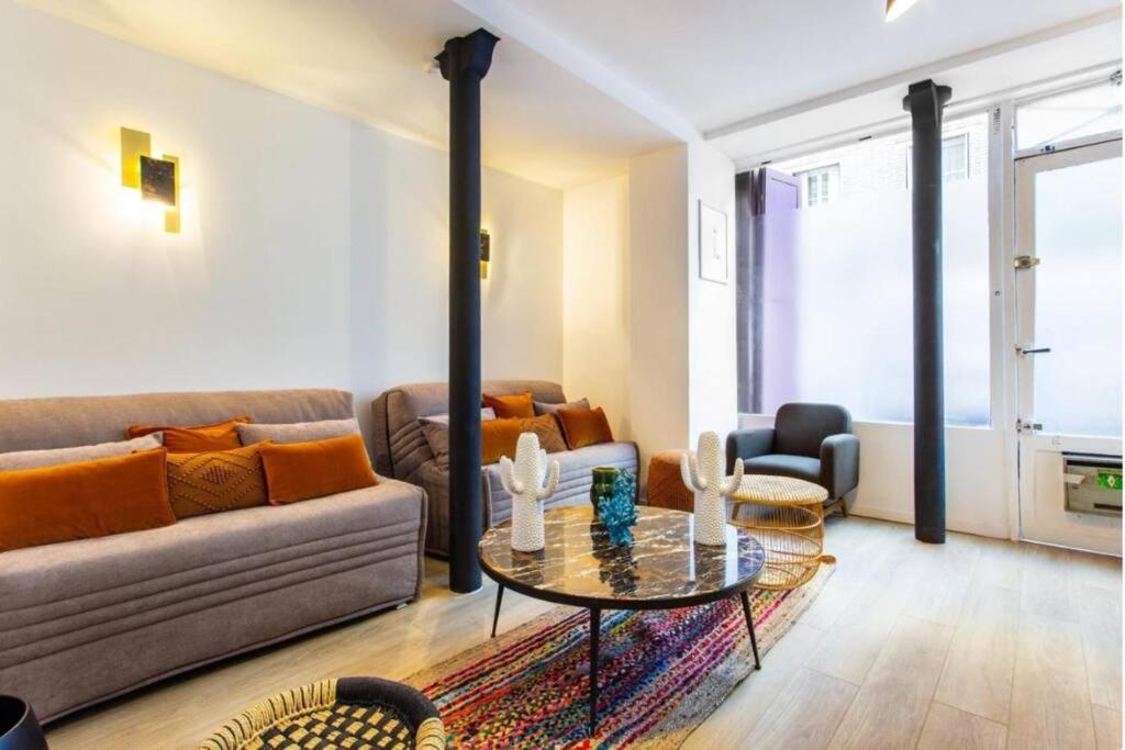 uma sala de estar com um sofá e uma mesa em St Germain-Bon Marché - cosy n°2 em Paris