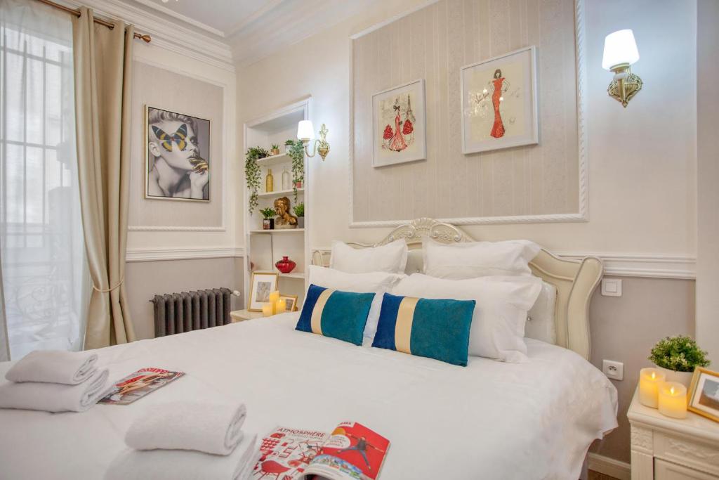 une chambre avec un grand lit blanc avec des oreillers dans l'établissement Charmant 150m2 5CH Romantic - Centre Ville - Clim, à Paris