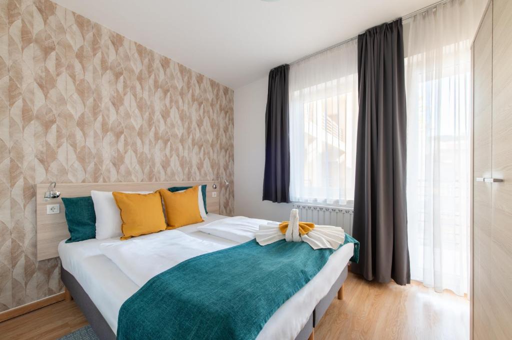 1 dormitorio con 1 cama grande con almohadas amarillas y azules en Prince Apartments, en Budapest