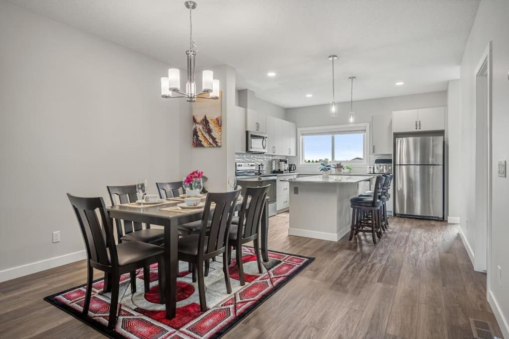 a kitchen and dining room with a table and chairs at Newly Built Family Townhome, Sleeps 12 Comfortably in Airdrie