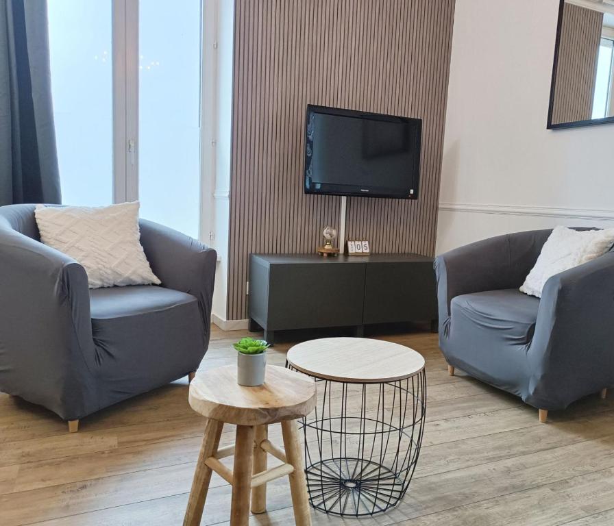 un salon avec deux canapés et une télévision dans l'établissement Le 1A, Charmant Appartement au Cœur de la Ville, à Gérardmer